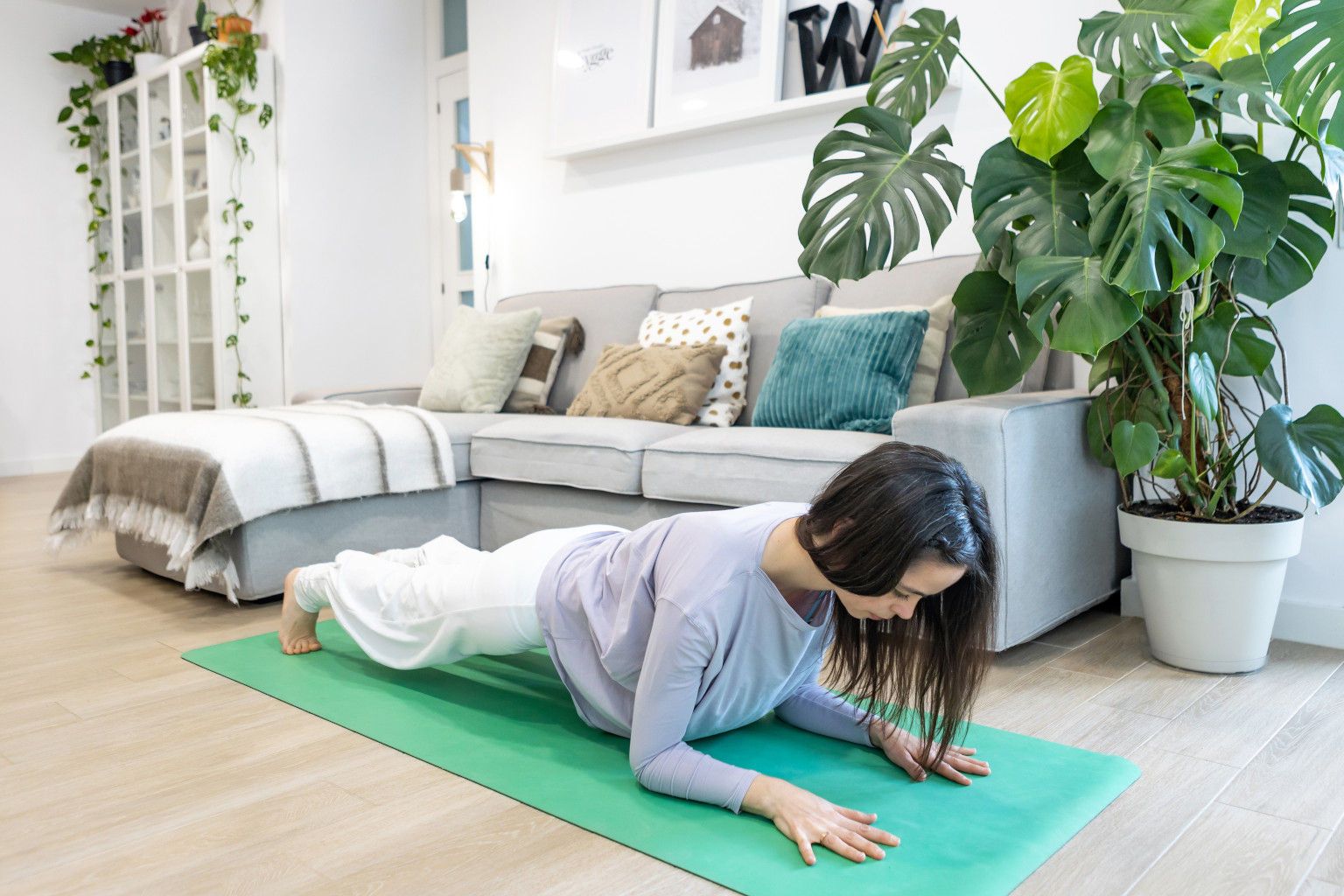 Mujer en la postura de la plancha en una clase de Yoga y meditación en casa