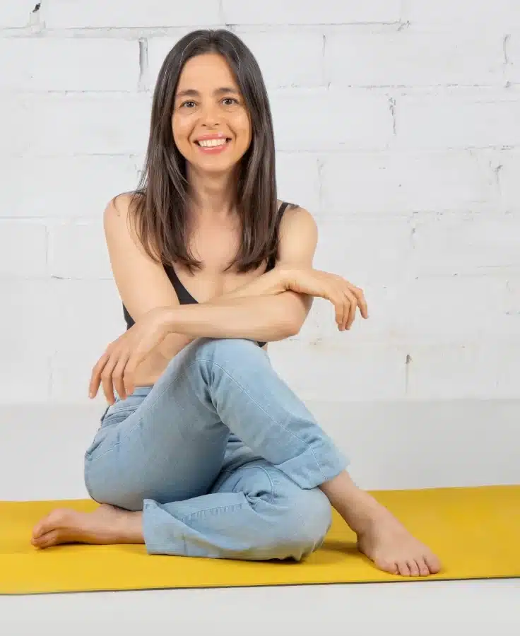 Vanessa sentada en el suelo sonriendo