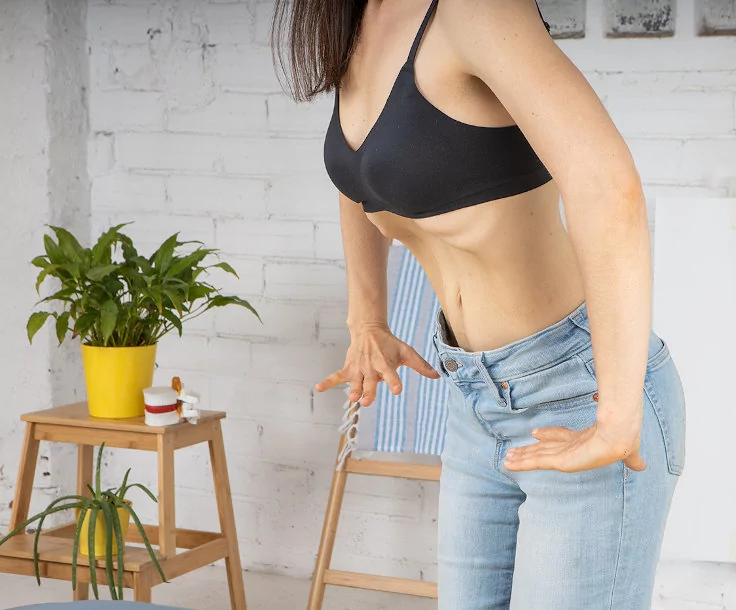 Beneficios hipopresivos suelo pelvico – Shivalans Plano medio de una mujer realizando hipopresivos con la apertura de costillas y la succión abdominal en apnea