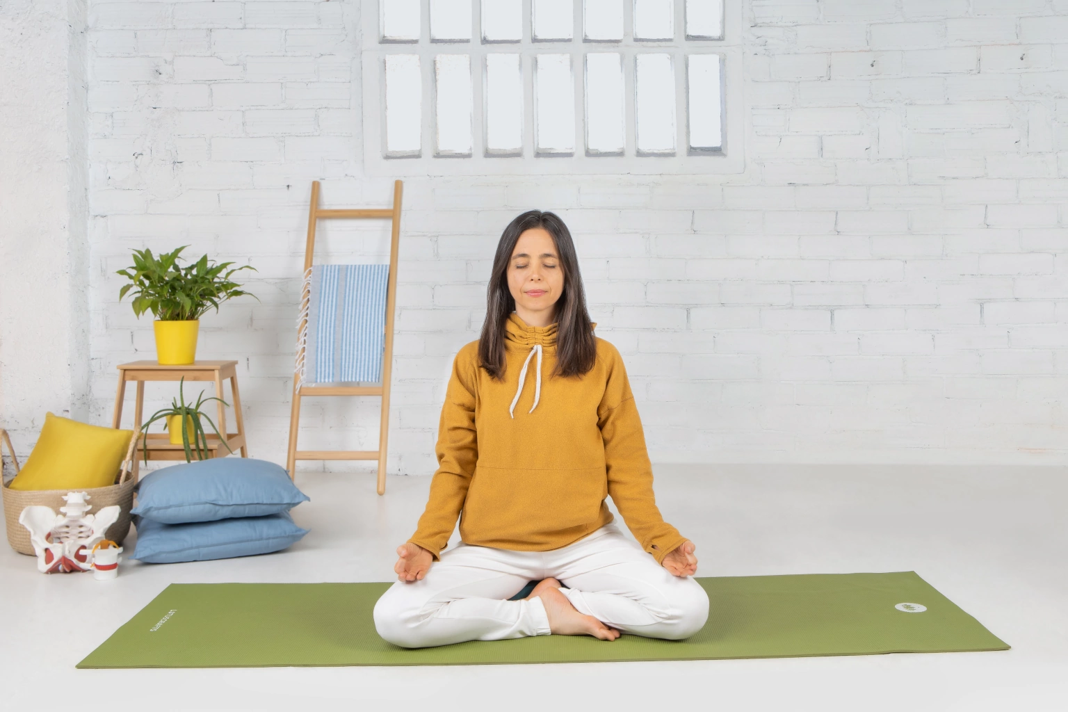 Hatha Yoga tradicional – Shivalans Vanessa sentada en una postura de meditación, con las piernas cruzadas y la columna erguida, transmitiendo calma en una clase de Yoga Online, practicando Hatha Yoga